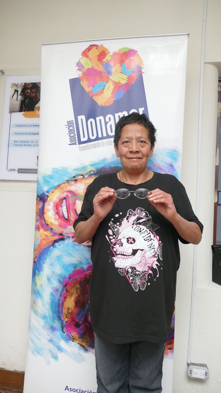Adolescente frente al banner de la Asociación Donamor