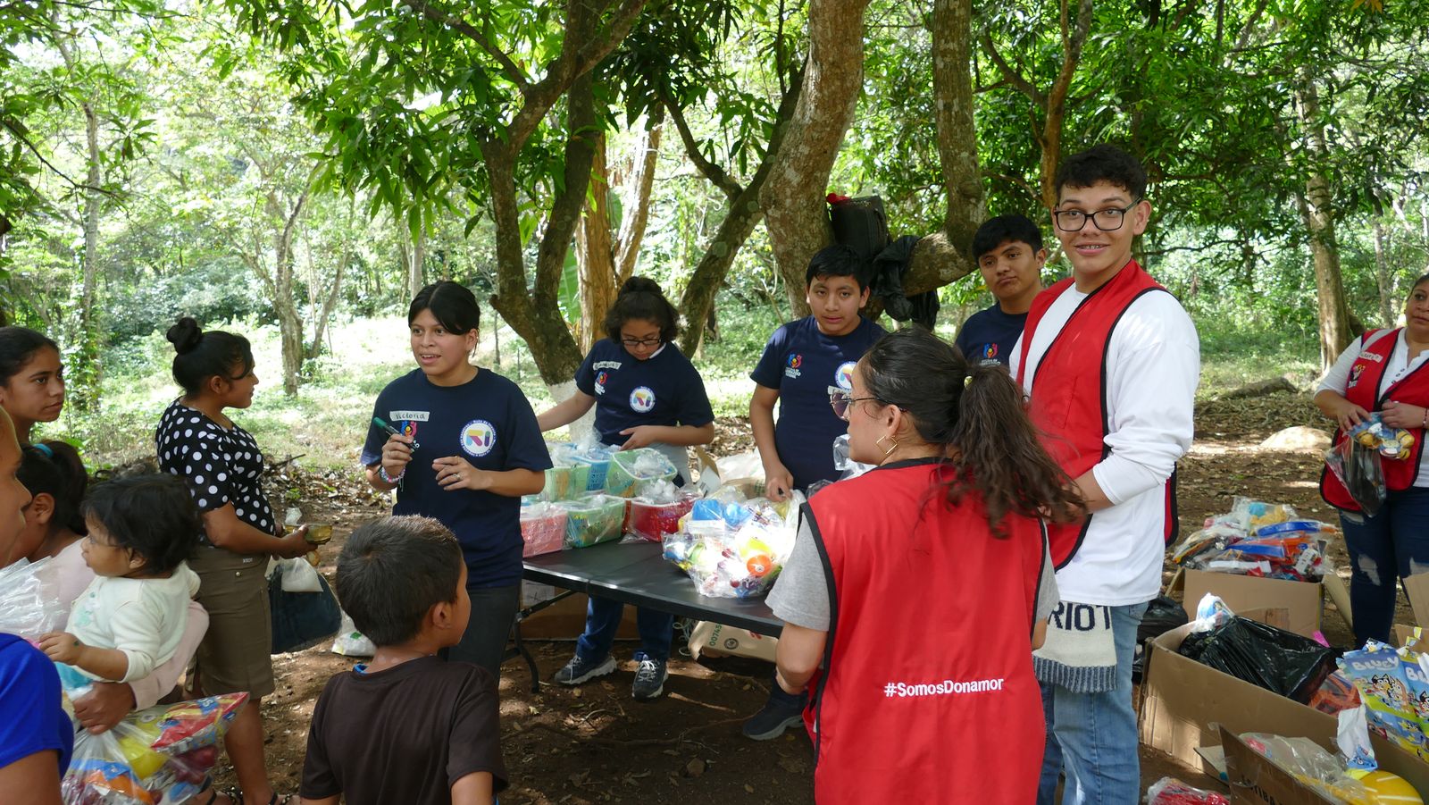Niñas y niños alrededor de las cajas de donaciones en una jornada comunitaria