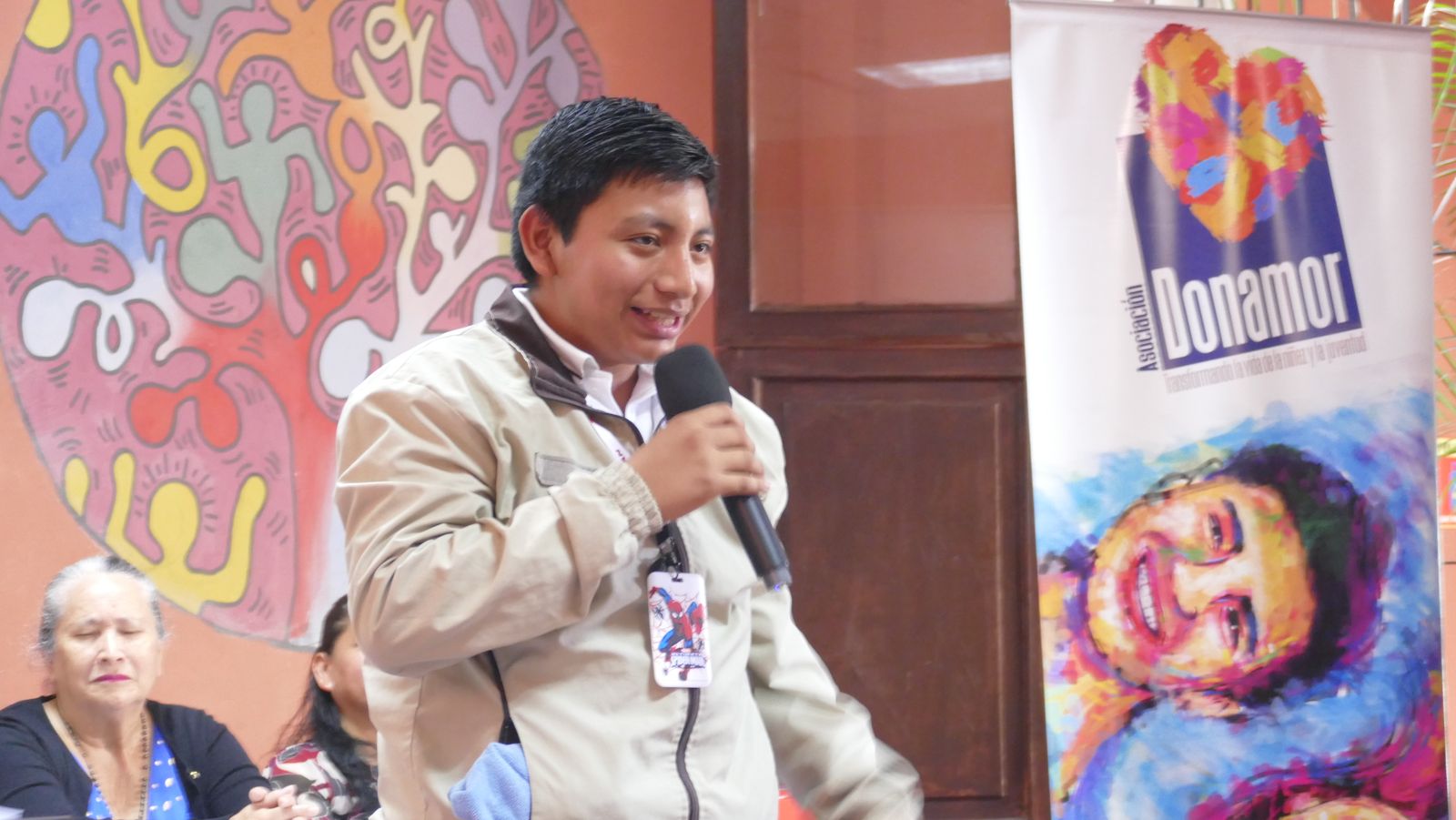 Facilitador de Donamor dirigiendo un taller frente al banner institucional