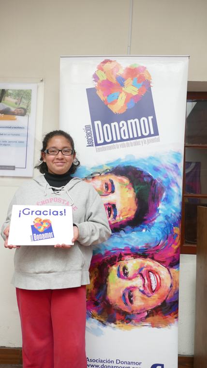 Participante sosteniendo un cartel de agradecimiento