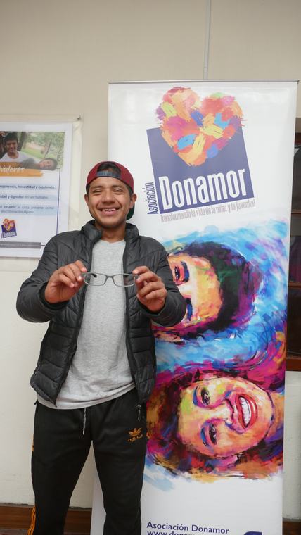 Joven con un mensaje de agradecimiento junto al banner institucional