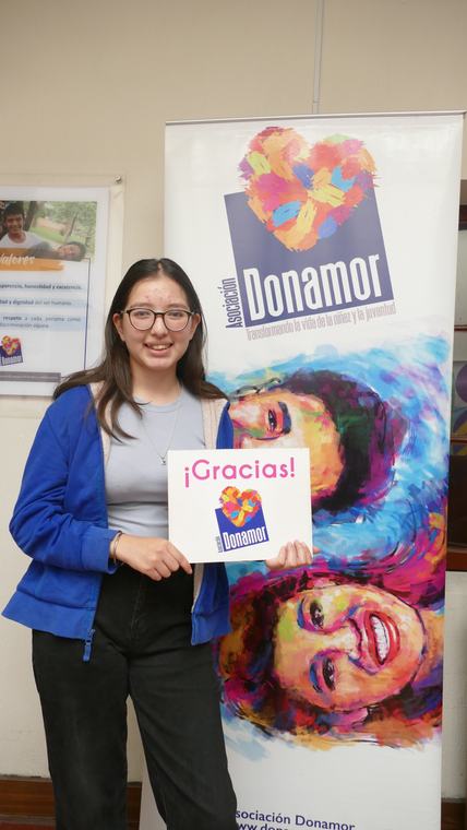 Adolescente sosteniendo un cartel de agradecimiento