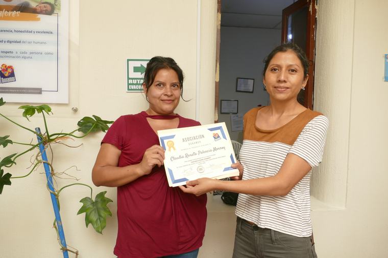 Entrega de diploma a una participante de los procesos formativos de Donamor