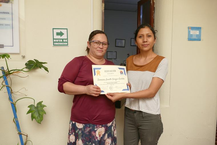 Entrega de diploma a una participante de los procesos formativos