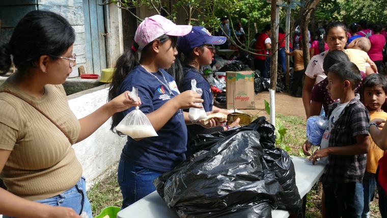 Voluntaria entregando insumos durante una jornada comunitaria