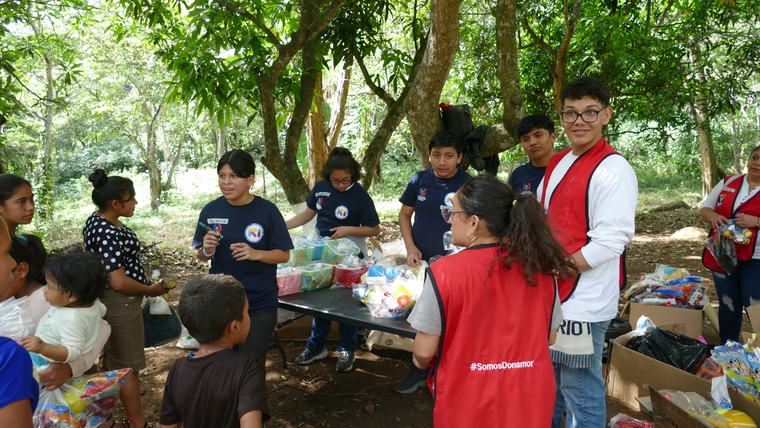 Niñas y niños alrededor de las cajas de donaciones